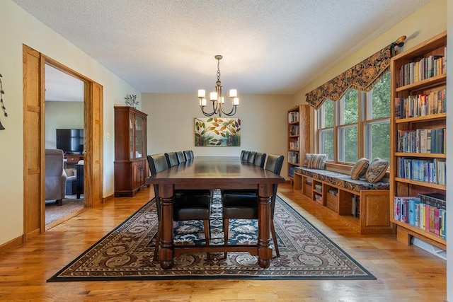 18505 210th Ave NE, Paynesville, MN 56362 - dining area featuring a chandelier, light wood finished floors, and a textured ceiling