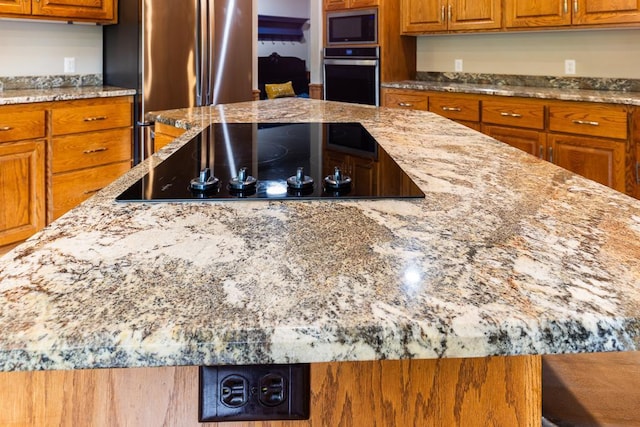 18505 210th Ave NE, Paynesville, MN 56362 - kitchen featuring stainless steel appliances, brown cabinetry, and light stone counters