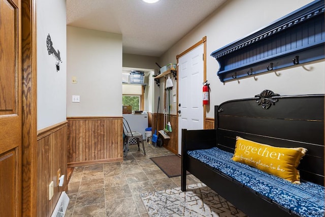 18505 210th Ave NE, Paynesville, MN 56362 - mudroom with wainscoting, wooden walls, a textured ceiling, and stone finish flooring