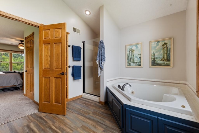 18505 210th Ave NE, Paynesville, MN 56362 - ensuite bathroom featuring wood finished floors, a whirlpool tub, a stall shower, lofted ceiling, and ceiling fan