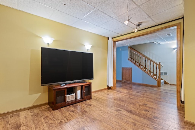 18505 210th Ave NE, Paynesville, MN 56362 - unfurnished living room with a drop ceiling, wood finished floors, and stairway