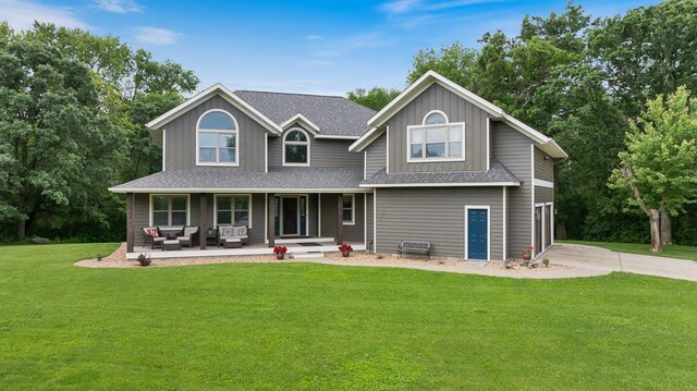18505 210th Ave NE, Paynesville, MN 56362 - view of front of home featuring covered porch, a shingled roof, a front lawn, concrete driveway, and an outdoor living space