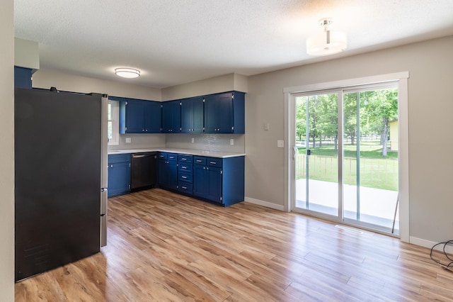 1744 Oak Rd, Saint Cloud, MN 56303 - kitchen featuring freestanding refrigerator, blue cabinets, dishwasher, light countertops, and light wood-style flooring