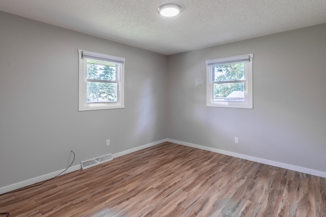 1744 Oak Rd, Saint Cloud, MN 56303 - unfurnished room with healthy amount of natural light, wood finished floors, and a textured ceiling