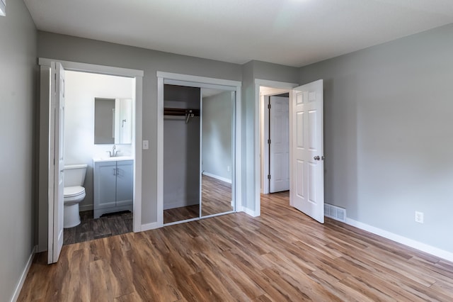 1744 Oak Rd, Saint Cloud, MN 56303 - unfurnished bedroom featuring wood finished floors, a closet, and ensuite bathroom