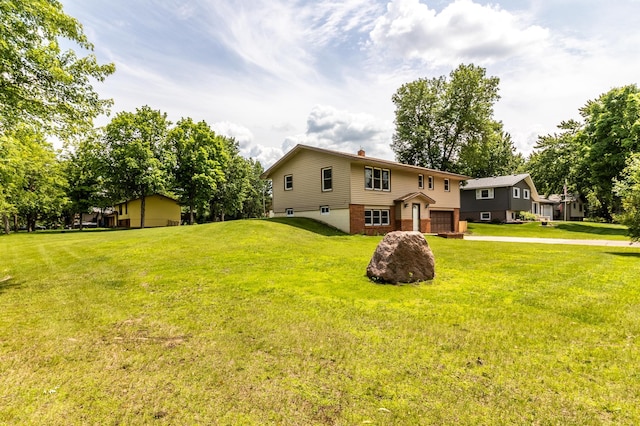 1744 Oak Rd, Saint Cloud, MN 56303 - back of house with a garage, driveway, a yard, and a chimney