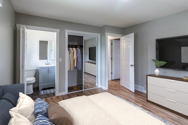 1744 Oak Rd, Saint Cloud, MN 56303 - bedroom with a closet, wood finished floors, and connected bathroom