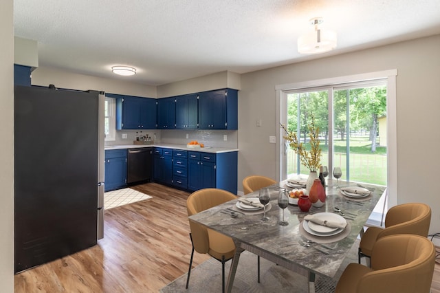 1744 Oak Rd, Saint Cloud, MN 56303 - kitchen featuring freestanding refrigerator, blue cabinetry, dishwasher, light wood-style floors, and light countertops