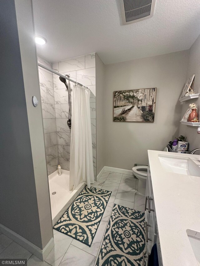 1004 Triumph Trl NE, Isanti, MN 55040 - bathroom with marble look tiles, a textured ceiling, a stall shower, and double vanity