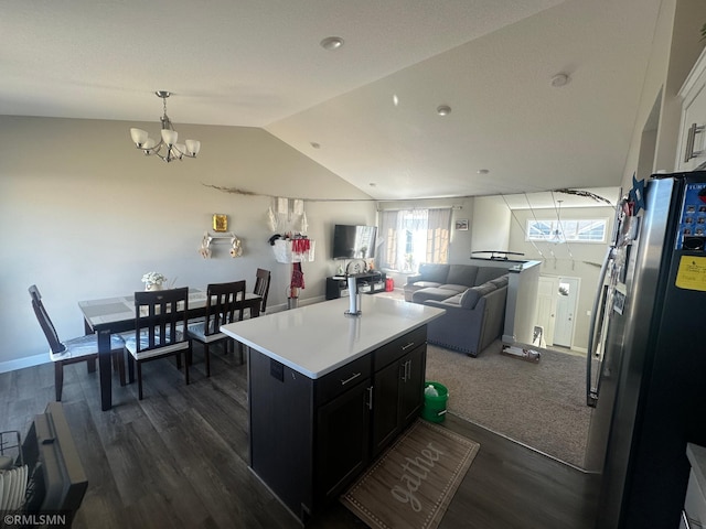 1004 Triumph Trl NE, Isanti, MN 55040 - kitchen with stainless steel fridge, vaulted ceiling, dark cabinetry, a chandelier, and light countertops