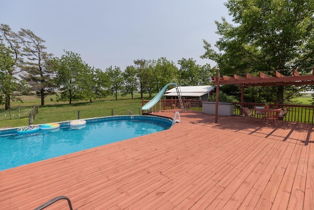 10706 65th Ave SE, Stewartville, MN 55976 - outdoor pool featuring a wooden deck, a water slide, a lawn, and view of scattered trees