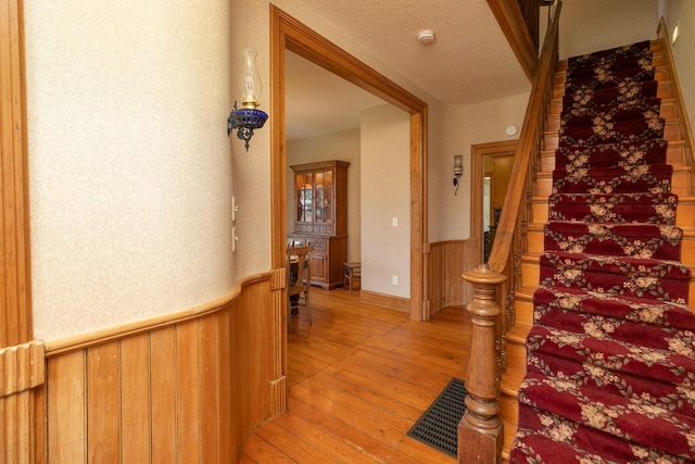10706 65th Ave SE, Stewartville, MN 55976 - stairway featuring hardwood / wood-style flooring and a wainscoted wall