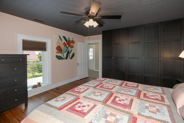 10706 65th Ave SE, Stewartville, MN 55976 - unfurnished bedroom with multiple windows, dark wood finished floors, and ceiling fan