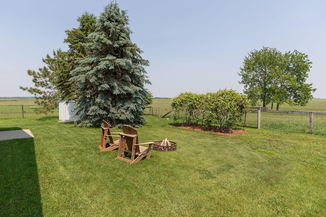 10706 65th Ave SE, Stewartville, MN 55976 - view of yard featuring an outdoor fire pit, a view of countryside, and a storage unit