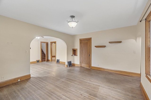 613 Oak St, Farmington, MN 55024 - empty room featuring arched walkways, light wood-type flooring, and stairs