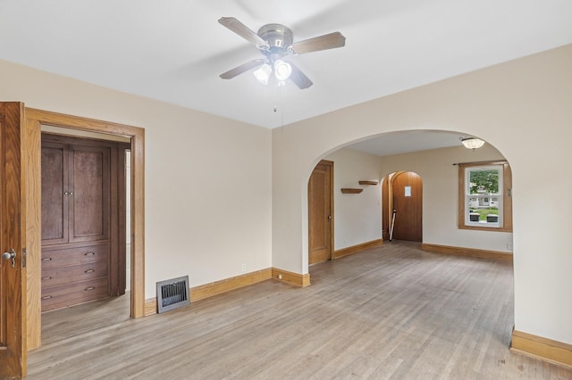 613 Oak St, Farmington, MN 55024 - empty room with arched walkways, light wood-type flooring, and ceiling fan