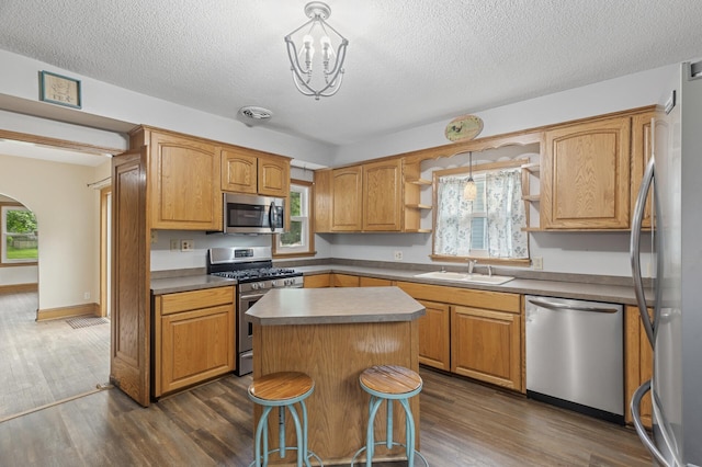 613 Oak St, Farmington, MN 55024 - kitchen featuring appliances with stainless steel finishes, open shelves, dark wood-style flooring, and a textured ceiling