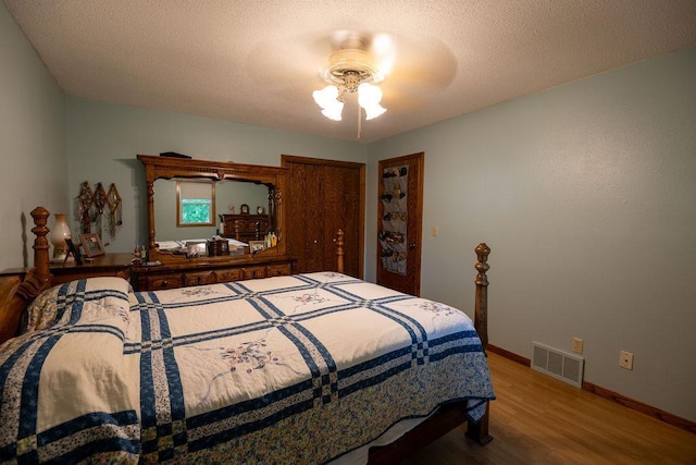 505 1st Ave, Raymond, MN 56282 - bedroom with wood finished floors, ceiling fan, a closet, and a textured ceiling