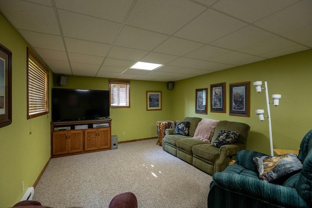 505 1st Ave, Raymond, MN 56282 - living room featuring a baseboard heating unit, light colored carpet, and a drop ceiling