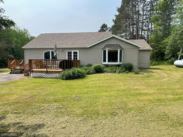 21507 County Road 560, Goodland Twp, MN 55742 - back of property with a deck, a shingled roof, and a lawn