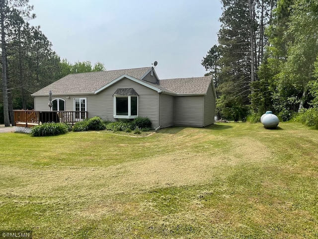 21507 County Road 560, Goodland Twp, MN 55742 - back of property with roof with shingles, a wooden deck, and a yard
