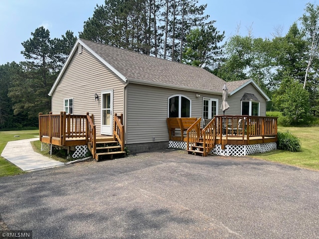 21507 County Road 560, Goodland Twp, MN 55742 - view of front facade featuring a wooden deck and a shingled roof