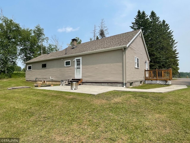 21507 County Road 560, Goodland Twp, MN 55742 - back of property featuring a deck, a patio, a chimney, and a lawn
