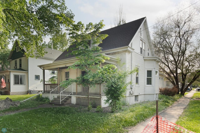 824 9th St N, Fargo, ND 58102 - view of front of house with covered porch, a front lawn, and roof with shingles