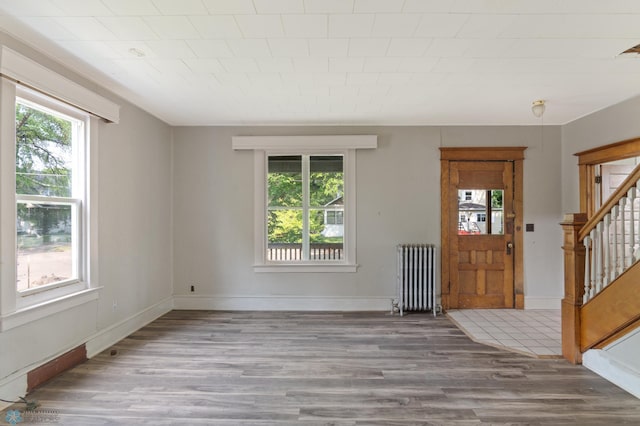 824 9th St N, Fargo, ND 58102 - entrance foyer featuring radiator heating unit, wood finished floors, and stairs