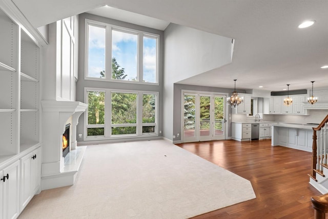 10701 Sonoma Rdg, Eden Prairie, MN 55347 - unfurnished living room with a chandelier, a fireplace, recessed lighting, wood finished floors, and stairs