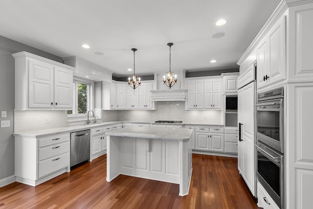 10701 Sonoma Rdg, Eden Prairie, MN 55347 - kitchen featuring stainless steel appliances, a chandelier, dark wood-style flooring, white cabinets, and a center island