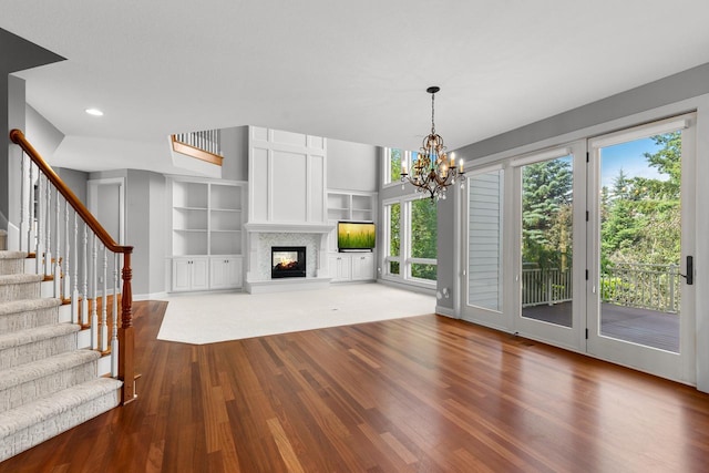 10701 Sonoma Rdg, Eden Prairie, MN 55347 - unfurnished living room featuring wood finished floors, stairs, built in shelves, recessed lighting, and a multi sided fireplace