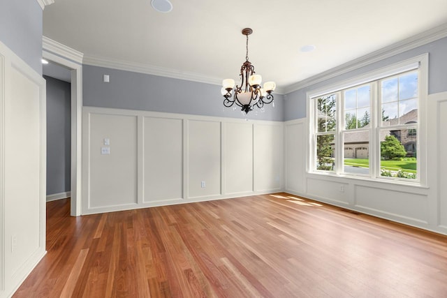 10701 Sonoma Rdg, Eden Prairie, MN 55347 - spare room with a decorative wall, a chandelier, light wood finished floors, crown molding, and wainscoting