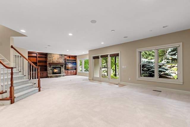 10701 Sonoma Rdg, Eden Prairie, MN 55347 - unfurnished living room with a stone fireplace, light carpet, stairway, recessed lighting, and built in shelves