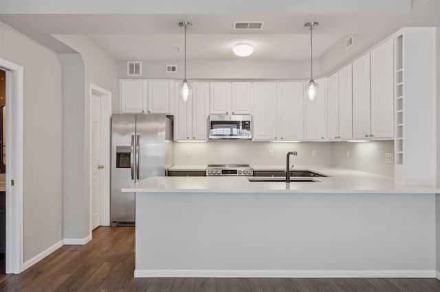 7601 Garfield Ave Unit 103, Richfield, MN 55423 - kitchen with stainless steel appliances, dark wood-style floors, white cabinetry, light countertops, and a peninsula