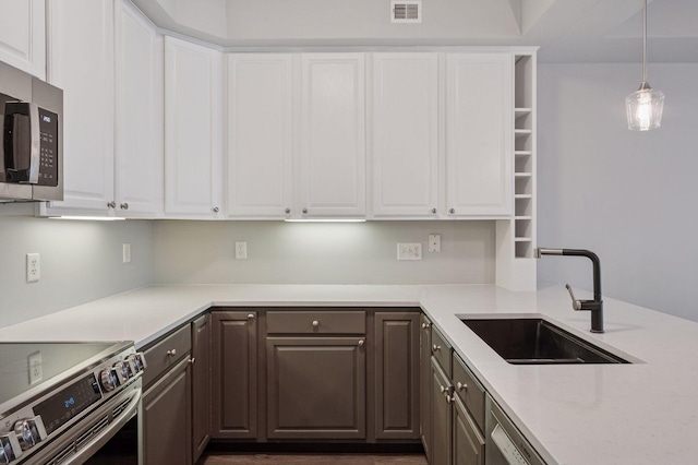 7601 Garfield Ave Unit 103, Richfield, MN 55423 - kitchen with stainless steel appliances, white cabinetry, dark brown cabinetry, pendant lighting, and open shelves