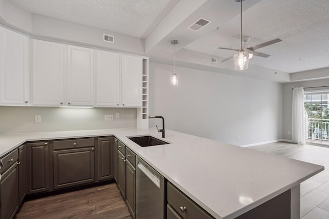 7601 Garfield Ave Unit 103, Richfield, MN 55423 - kitchen featuring stainless steel dishwasher, a peninsula, a textured ceiling, a ceiling fan, and white cabinets