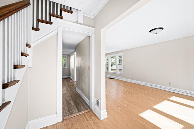 808 6th Ave E, Duluth, MN 55805 - hallway with wood-type flooring, a baseboard radiator, and stairway