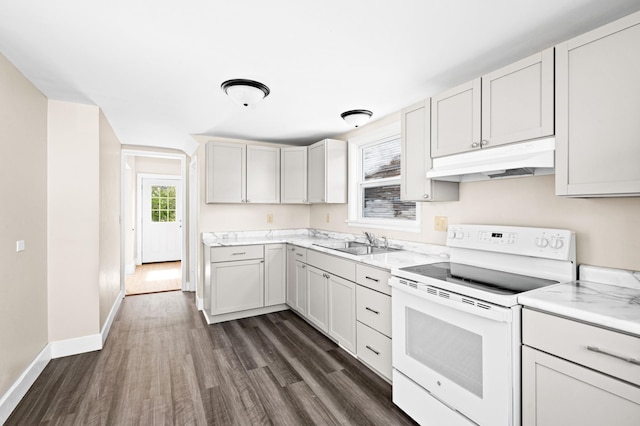 808 6th Ave E, Duluth, MN 55805 - kitchen featuring white range with electric stovetop, under cabinet range hood, dark wood-style floors, and light countertops