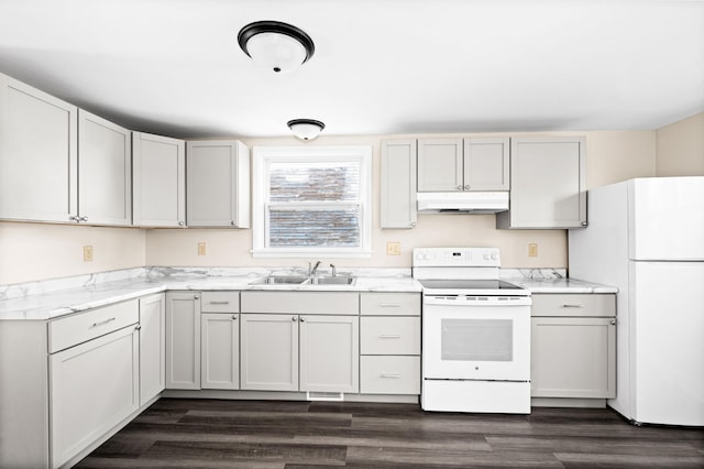 808 6th Ave E, Duluth, MN 55805 - kitchen with white appliances, under cabinet range hood, and dark wood-style floors