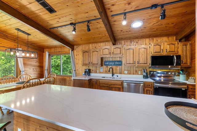 36388 Wabana Rd, Wabana Twp, MN 55744 - kitchen with appliances with stainless steel finishes, track lighting, wood walls, a wood ceiling with exposed beams, and light countertops