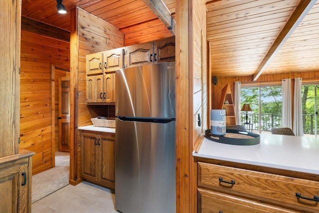 36388 Wabana Rd, Wabana Twp, MN 55744 - kitchen featuring freestanding refrigerator, a wooden ceiling with exposed beams, wooden walls, brown cabinetry, and light countertops