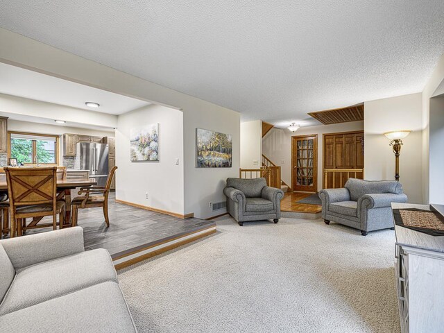 4125 Bridgewater Cir, Vadnais Heights, MN 55127 - living room featuring stairway, light colored carpet, and a textured ceiling