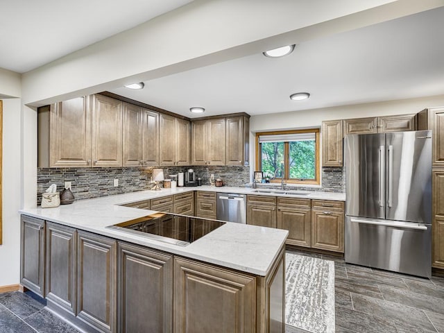 4125 Bridgewater Cir, Vadnais Heights, MN 55127 - kitchen featuring appliances with stainless steel finishes, tasteful backsplash, a peninsula, light stone countertops, and recessed lighting