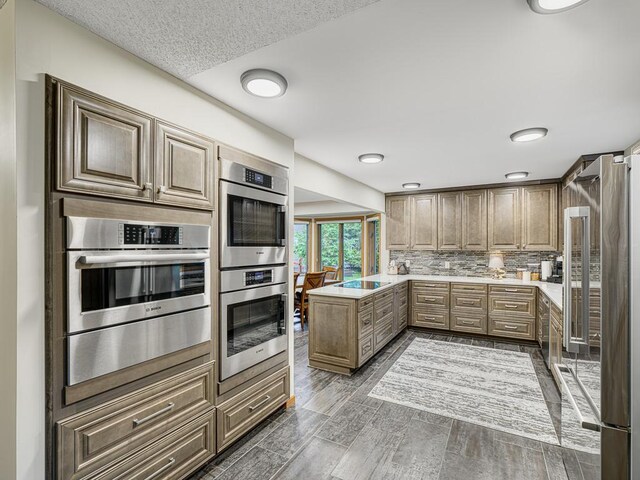 4125 Bridgewater Cir, Vadnais Heights, MN 55127 - kitchen with stainless steel appliances, light countertops, backsplash, and a peninsula