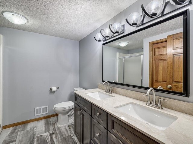 4125 Bridgewater Cir, Vadnais Heights, MN 55127 - bathroom with a shower stall, a textured ceiling, double vanity, and wood finished floors