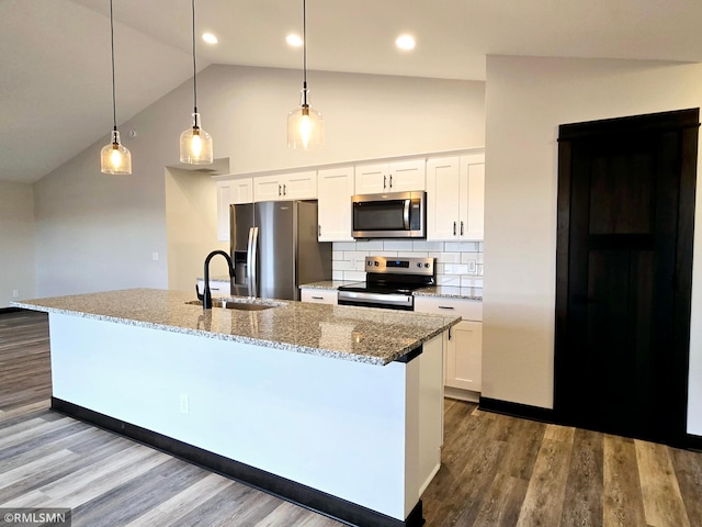 2001 Essler Dr, Saint Peter, MN 56082 - kitchen featuring stainless steel appliances, lofted ceiling, white cabinets, dark wood finished floors, and tasteful backsplash