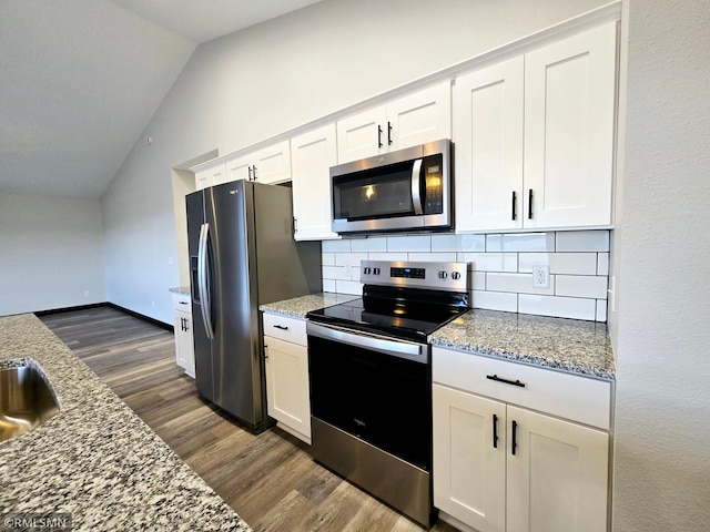 2001 Essler Dr, Saint Peter, MN 56082 - kitchen with stainless steel appliances, vaulted ceiling, dark wood-style floors, backsplash, and white cabinets