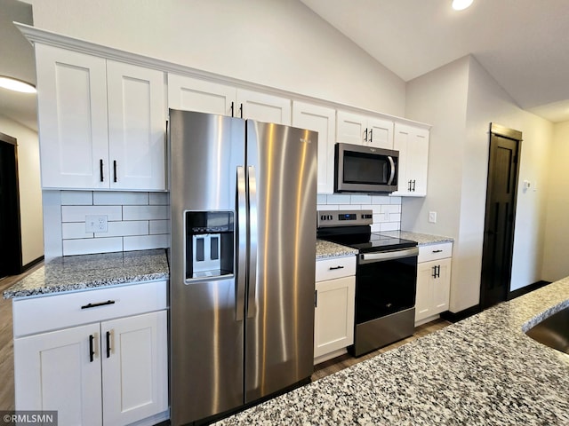2001 Essler Dr, Saint Peter, MN 56082 - kitchen with stainless steel appliances, dark wood-style flooring, light stone countertops, decorative backsplash, and vaulted ceiling