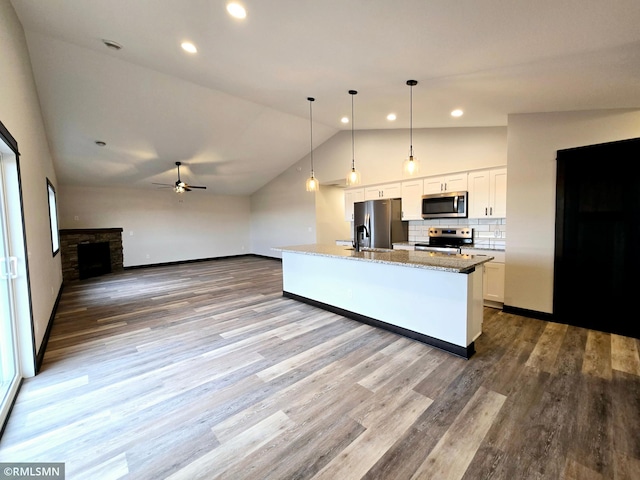 2001 Essler Dr, Saint Peter, MN 56082 - kitchen with stainless steel appliances, lofted ceiling, ceiling fan, white cabinets, and light stone countertops